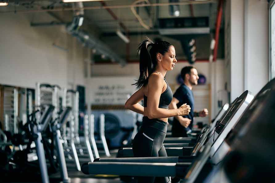 En kvinna springer p ett lpband p ett gym. 