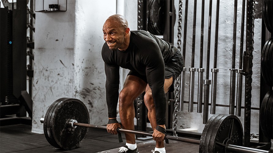 En man i gymmilj� drar ett marklyft.