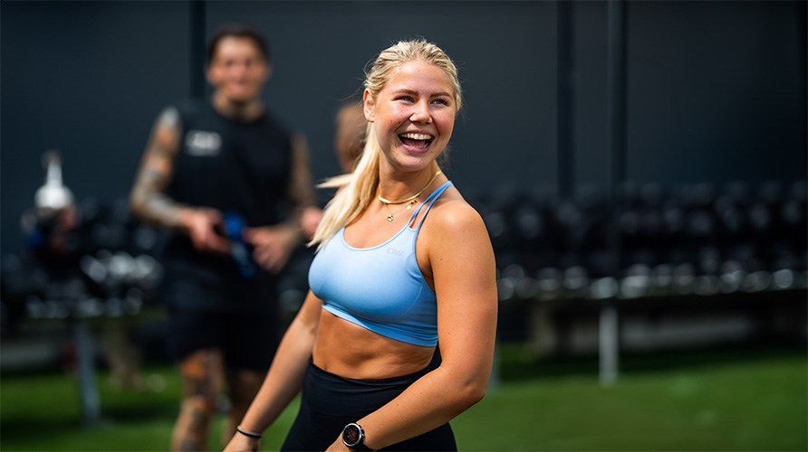 Linn Leijonqvist skrattar p ett gym infrd trningsklder. 