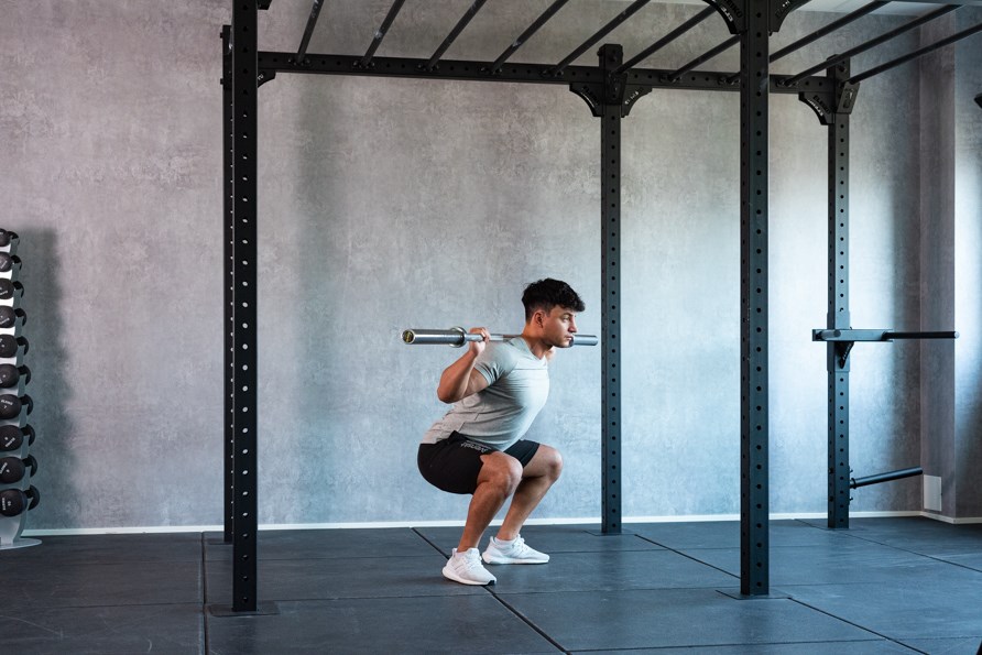 Man gör träningsövningen knäböj. Man gör träningsövningen knäböj.