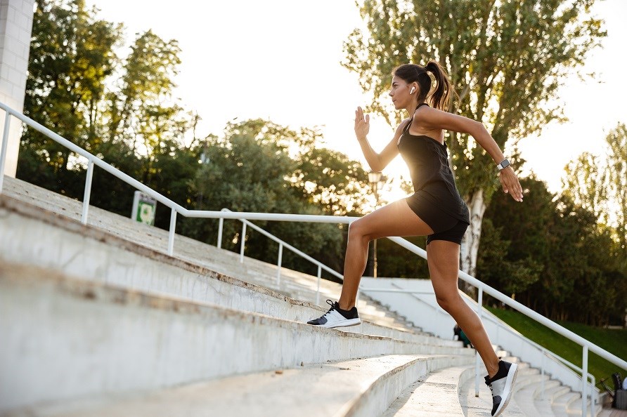 Kvinna som tränar springer upp för en trappa.